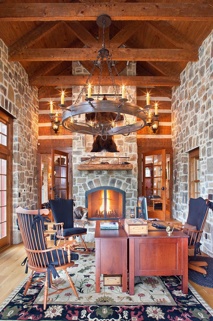 An office space includes a bull's head hanging above the fireplace. 