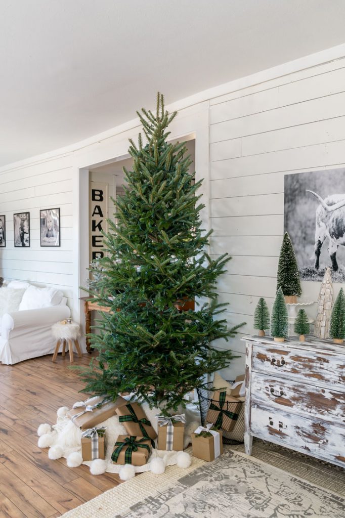 A simple pine tree with twinkle lights and brown paper presents beneath it.