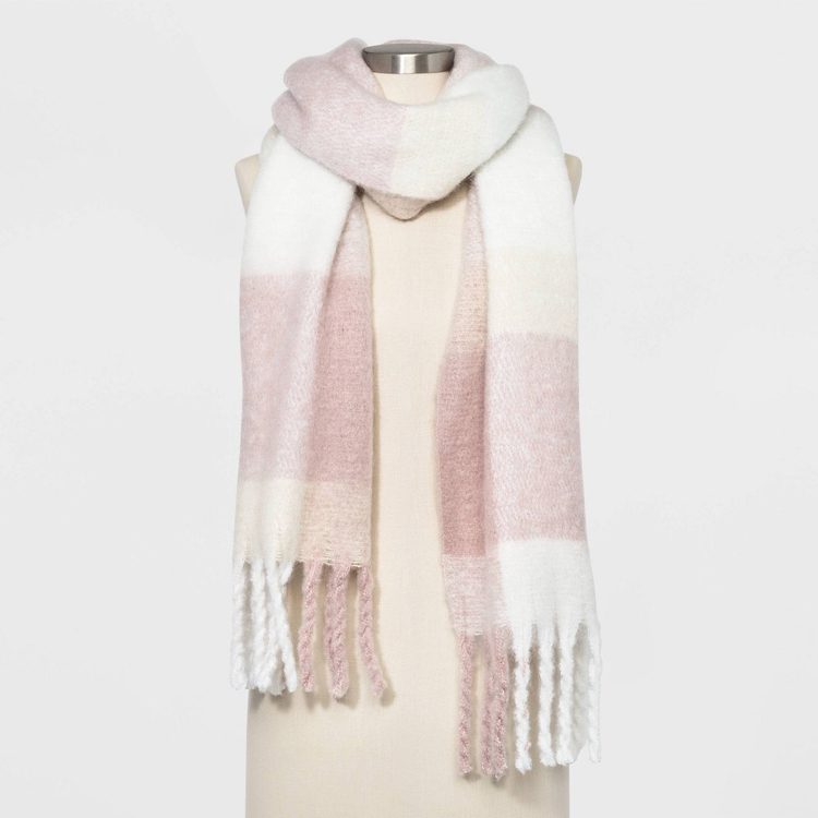Cream colored scarf with large pale pink plaid blocking and a long fringe.