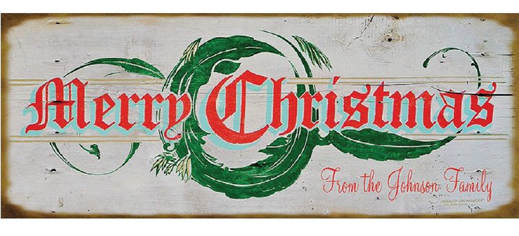 Personalized rustic wood "Merry Christmas" sign with old-fashioned red font in front of a swirled-green wreath painting.