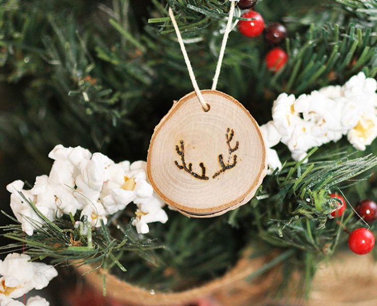 Wood chip ornament with small burned antler outlines on them.