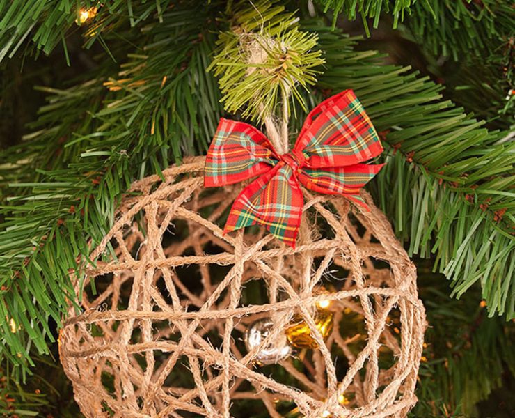 Hollow twine sphere ornament with a red and green plaid bow.