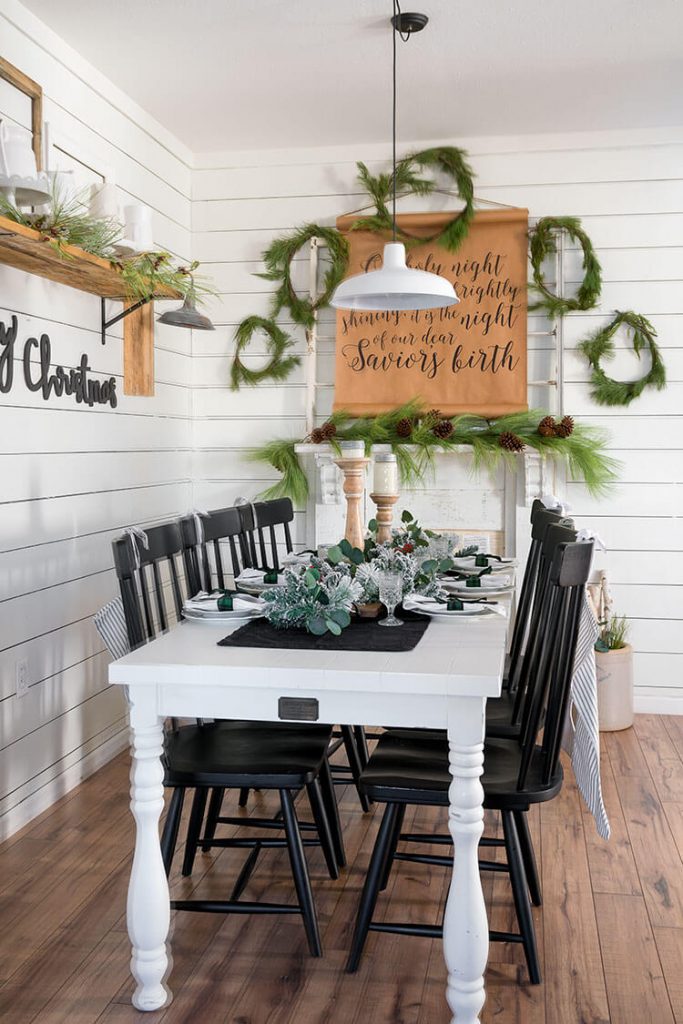 Hosting a party with a table set with fresh holiday greenery 
