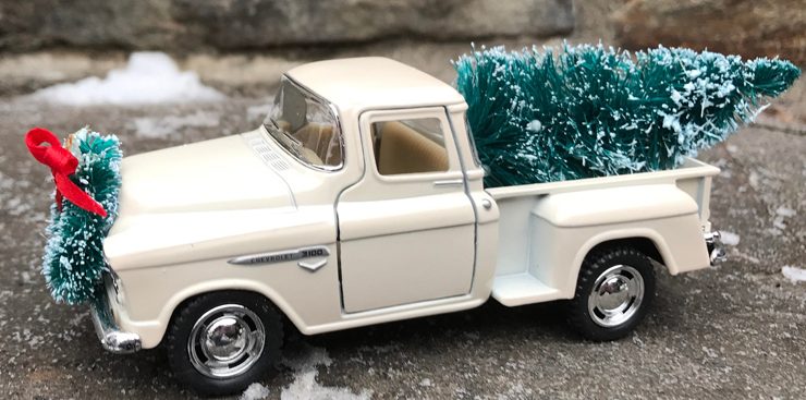 A mini vintage-truck model in a cream color with a mini Christmas tree in the truck bed—a farm-fresh Christmas decor item, for sure.