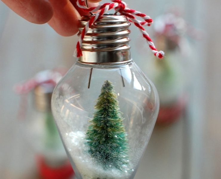Small lightbulb with white glitter and mini Christmas tree inside it.