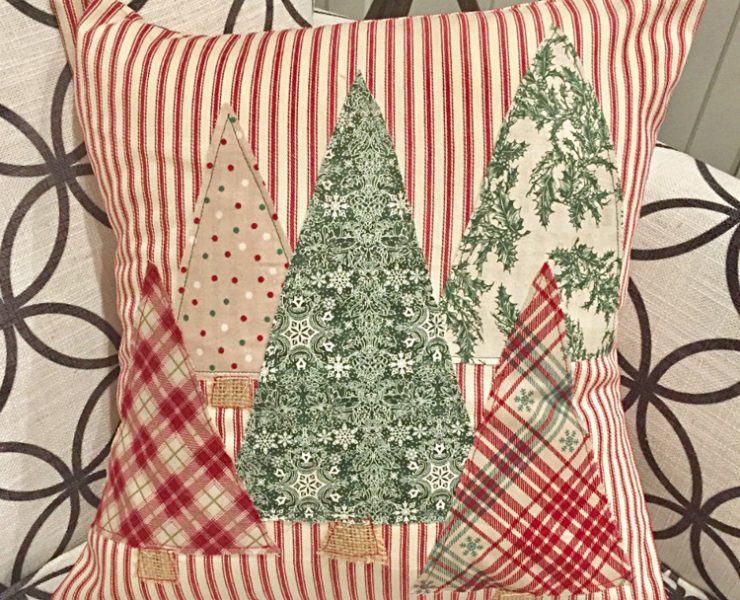 A pillow cover with red and white stripes and 5 patterned fabric tree decals.