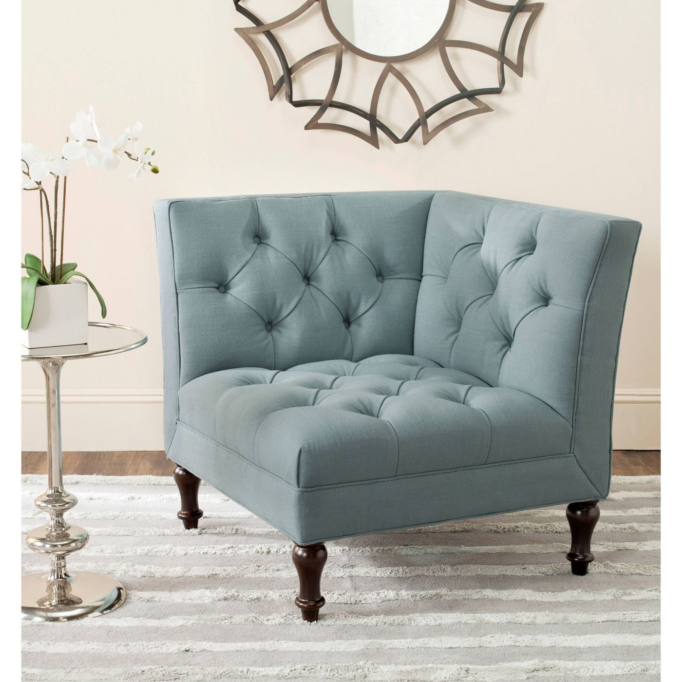 This piece of farmhouse furniture is a light blue, tufted accent chair.