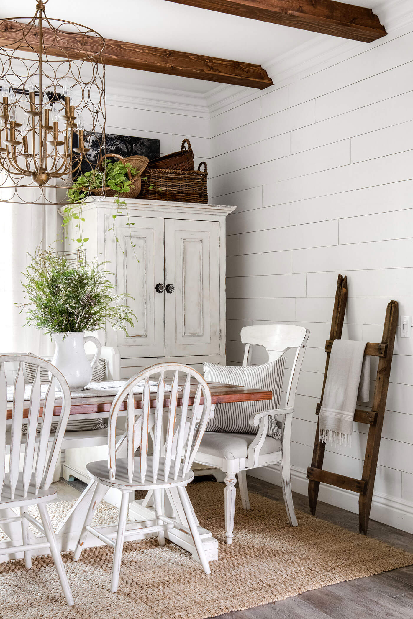 Vintage charm in dining room with exposed ceiling beams, shiplap and vintage furniture