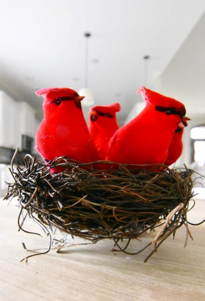 cardinlas reside in a nest ready for the final steps in decorating a Christmas mantel
