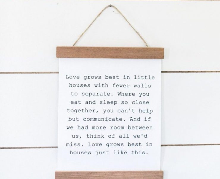 White canvas with black typewriter print quote with a piece of wood at the top and bottom.