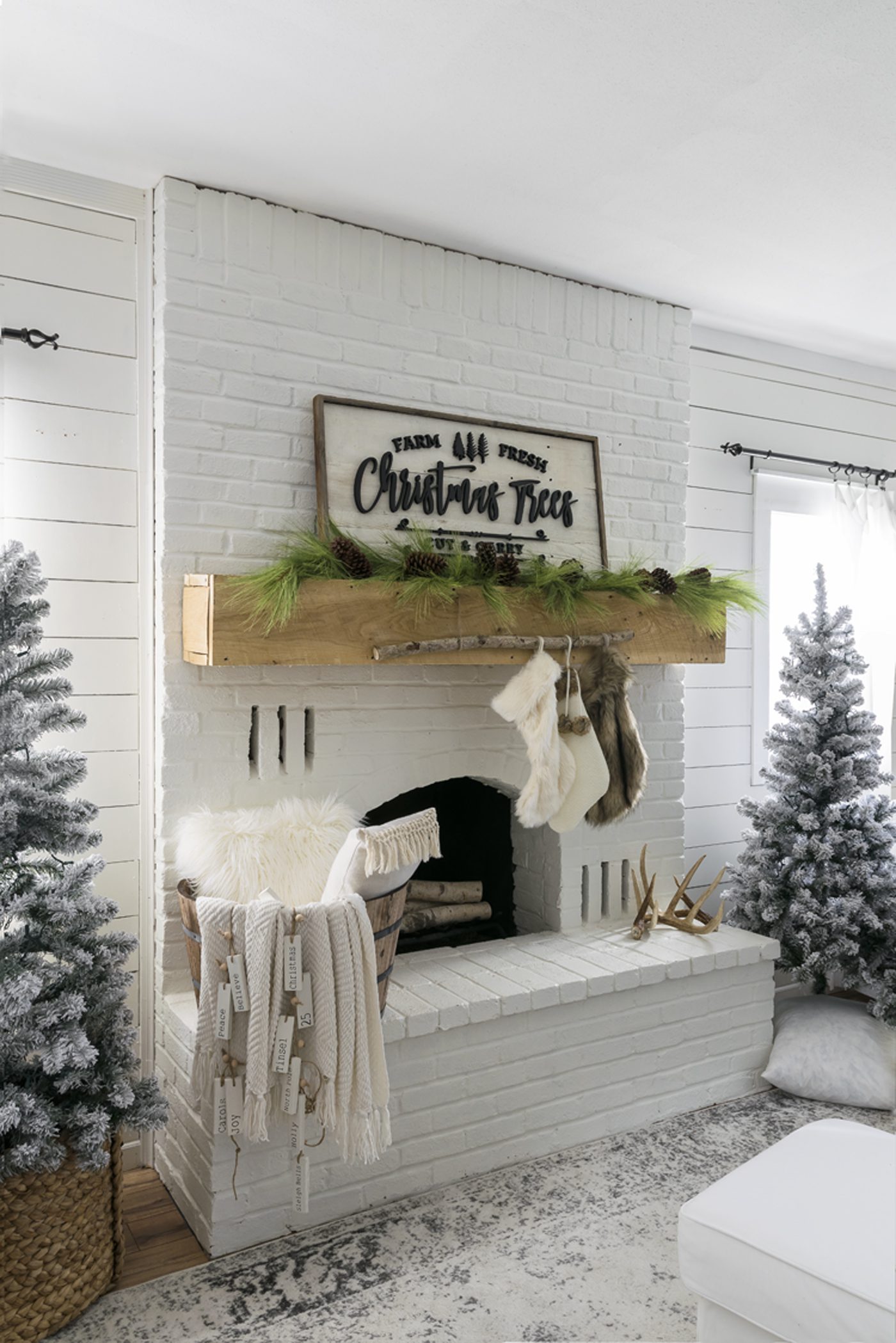 Jo's fireplace with her DIY stocking holder—a thin birch branch hanging from the mantel with faux fur stockings.