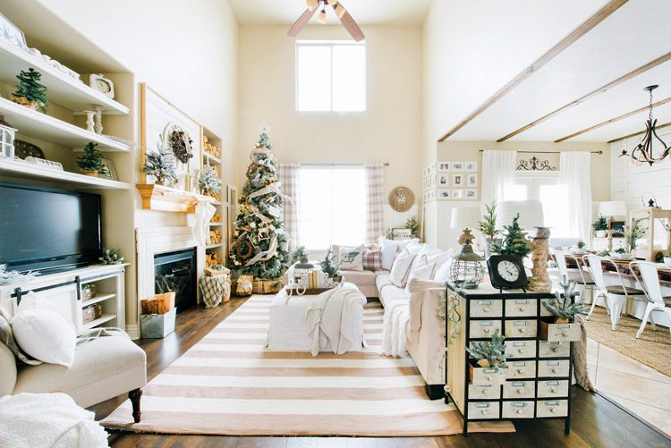 A full view of the neutrally decorated living room with a very high ceiling and a lot of natural light through the windows.