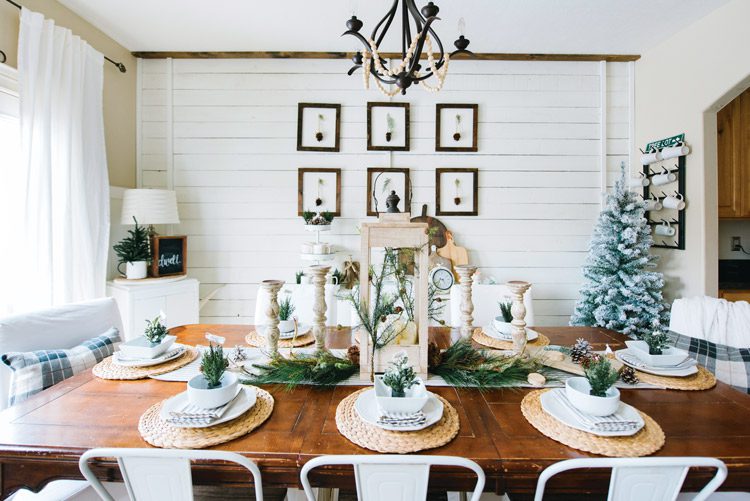 Dining room table decorated with natural greenery and wood decor.