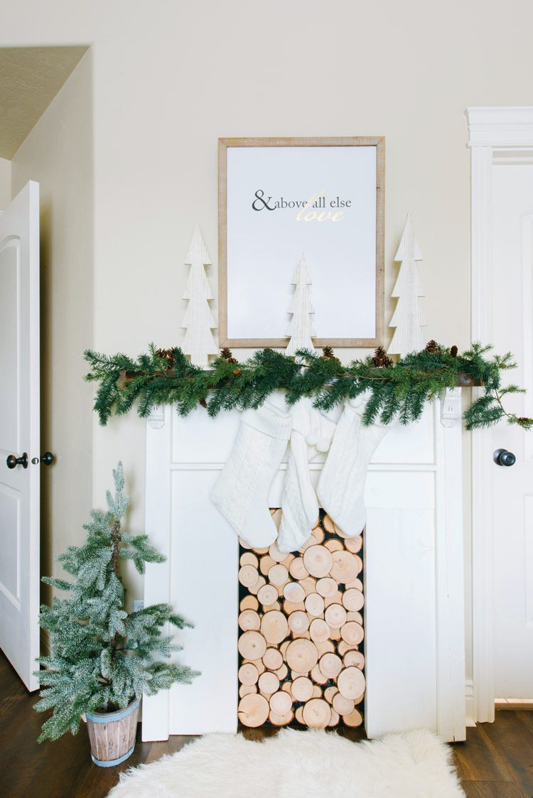 Utah farmhouse faux fireplace with wood chips, stockings and a garland.