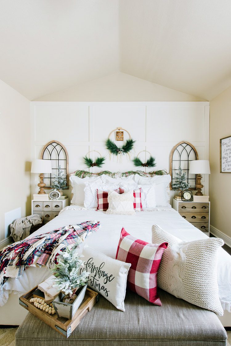 Master bedroom bed with two side tables and red-checkered pillows.