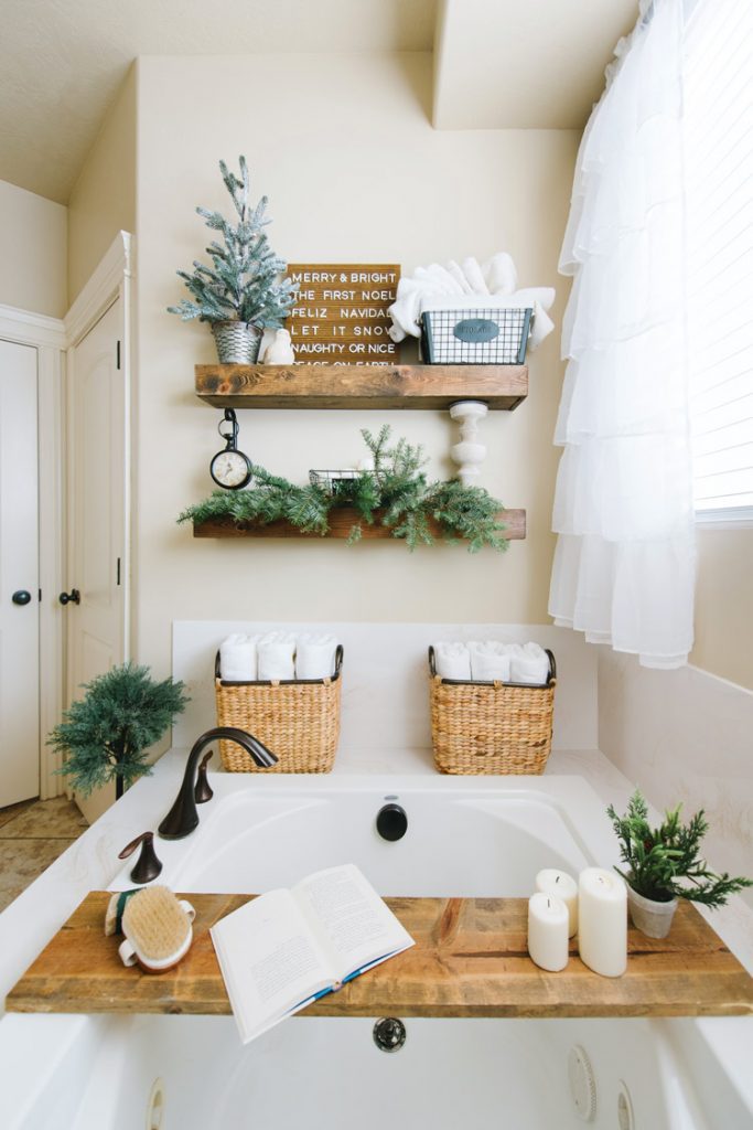 Two floating shelves above one side of the bath tub with greenery and decorative storage containers.