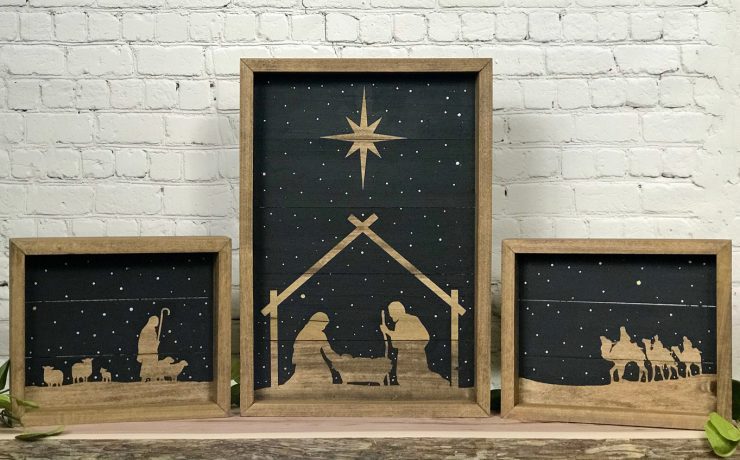 Nativity set of three wood pieces with a black background to make the silhouettes of the manger scene stand out.