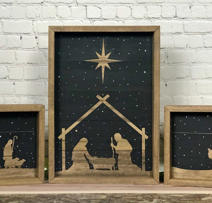 Nativity set of three wood pieces with a black background to make the silhouettes of the manger scene stand out.