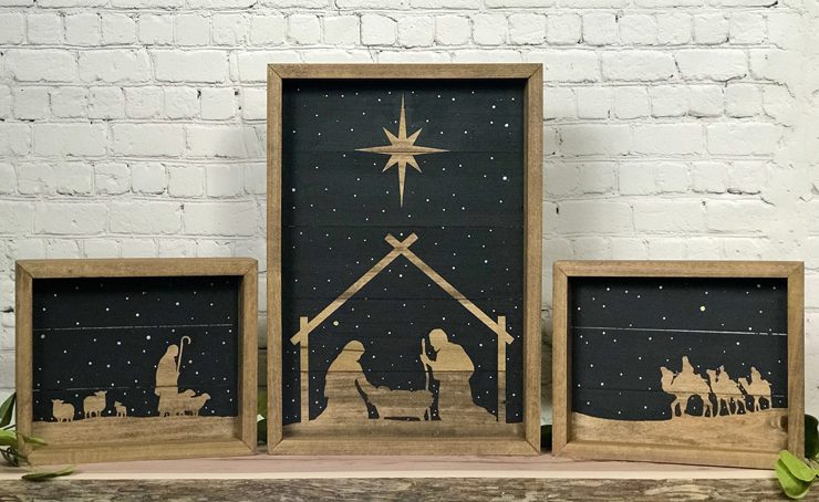 Three-piece Nativity set with black background and wooden silhouettes.