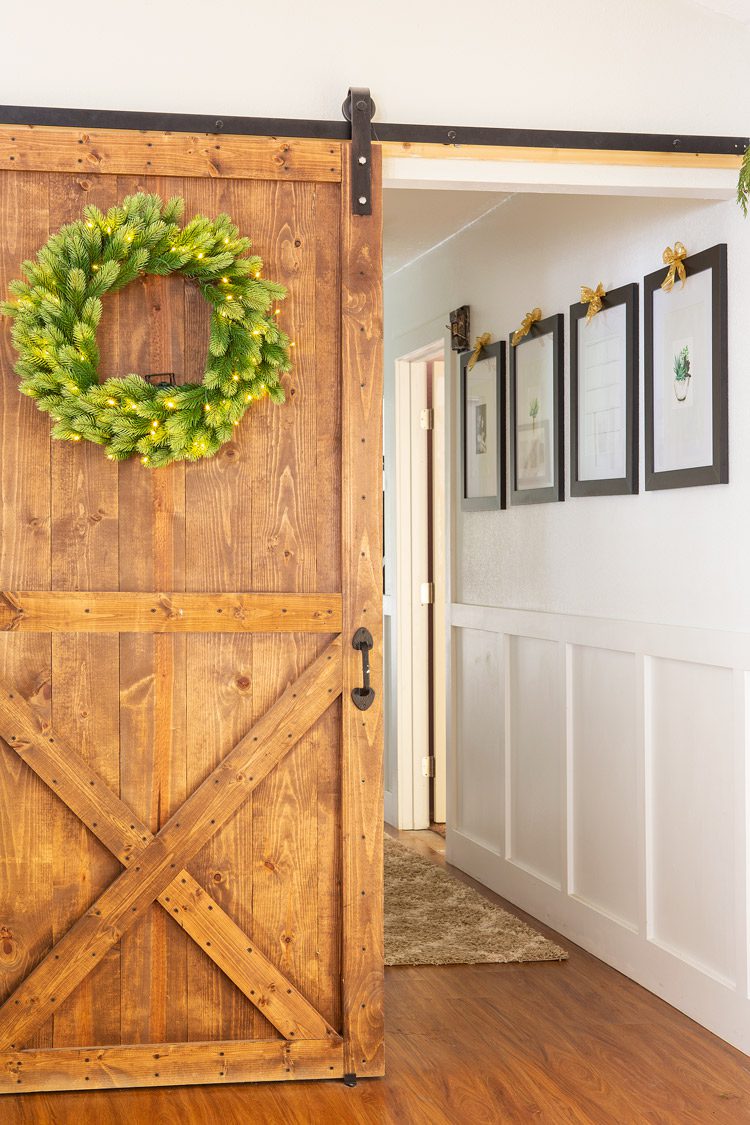 Stained wood sliding barn door leading to the hallway.