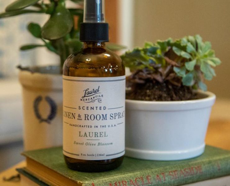 Brown glass bottle of scented room spray with paper white label.