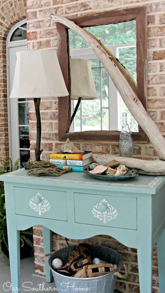 After picture: Light seafoam green desk with white stenciled designs on the drawers and top.