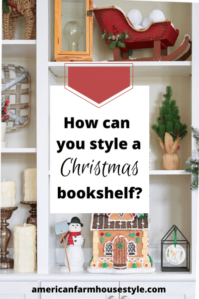 Open shelves in a Christmas bookcase decorated with Christmas decor, including a gingerbread house with an elf-on-the-shelf on the roof.