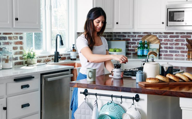A woman makes coffee in a modern farmhouse kitchen