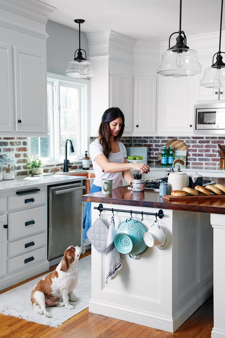 A woman makes coffee in a modern farmhouse kitchen