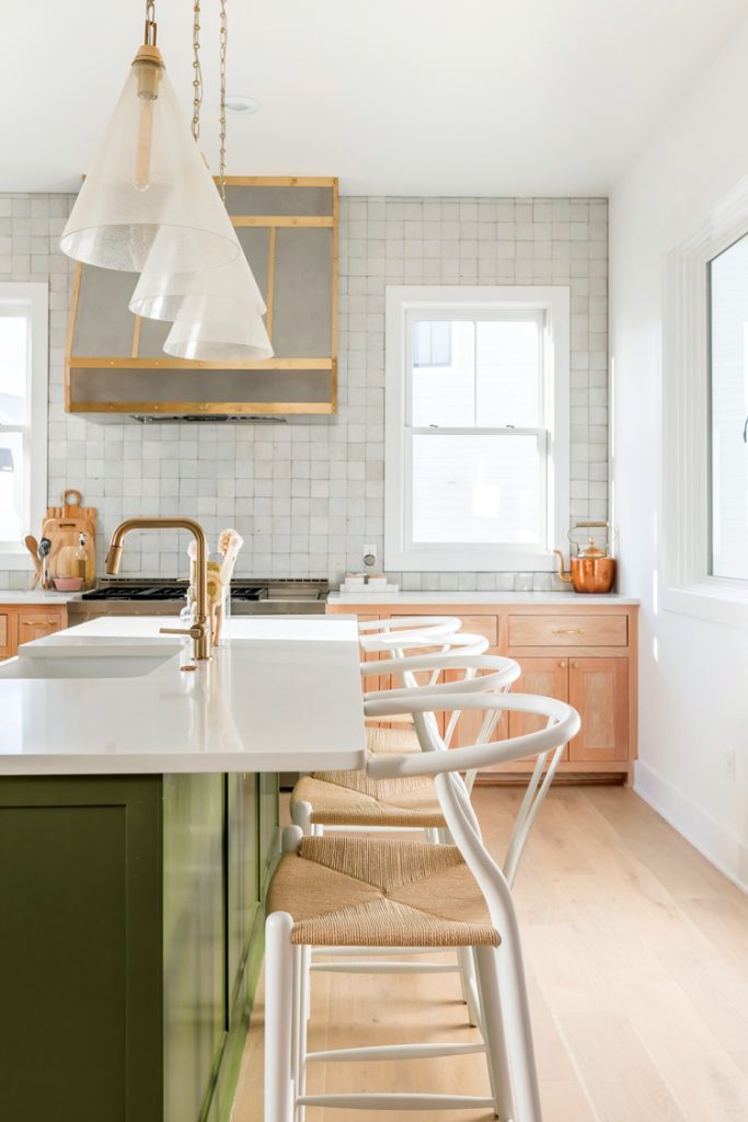 Kitchen with green island and hanging pendant lights