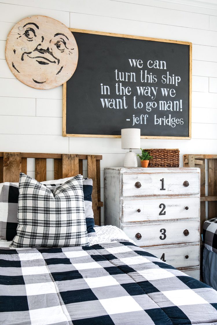 A chalkboard that says "we can turn this ship in the way we want to go man." Beside the chalkboard is a vintage artwork of a round moon with a smiling face.