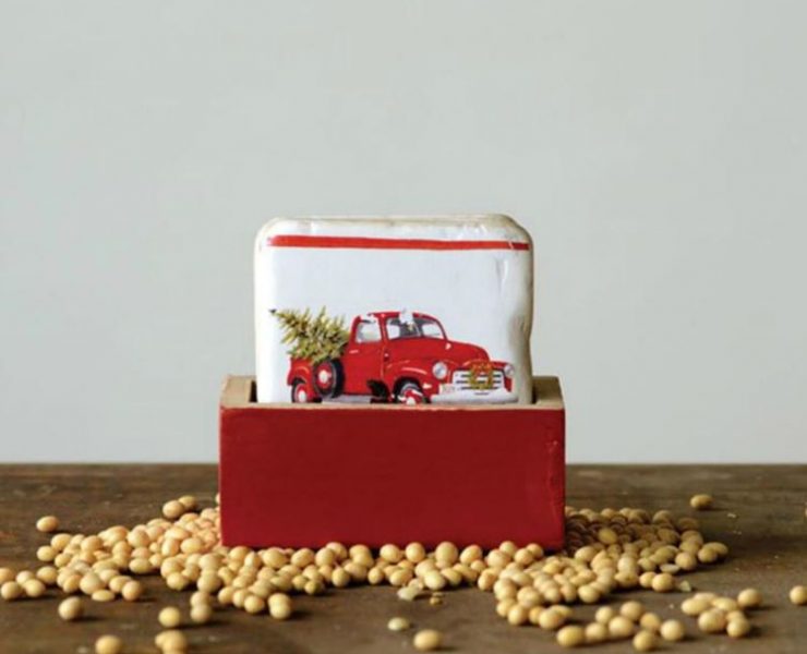 A set of coasters with an image of a red truck with a Christmas tree in a rustic red box