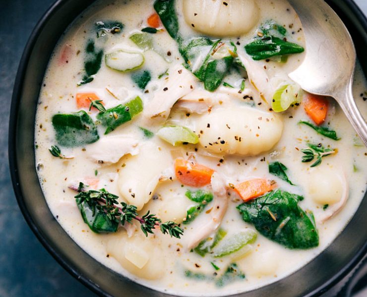 Bowl full of creamy chicken gnocchi soup with spinach leaves, one of our favorite farmhouse soup recipes.