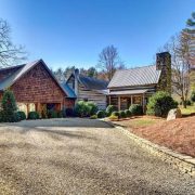 A large cabin in North Carolina with a paved road and old style cabin wood and mortor