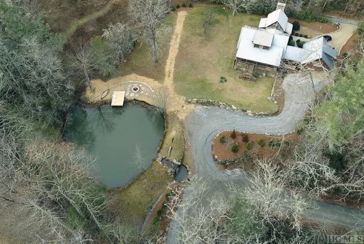 An aerial view of the property which includes the private lake, waterfall, hiking trails, and beautiful forests surrounding the property