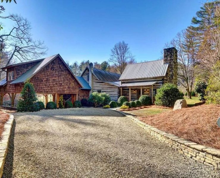 A large cabin in North Carolina with a paved road and old style cabin wood and mortor