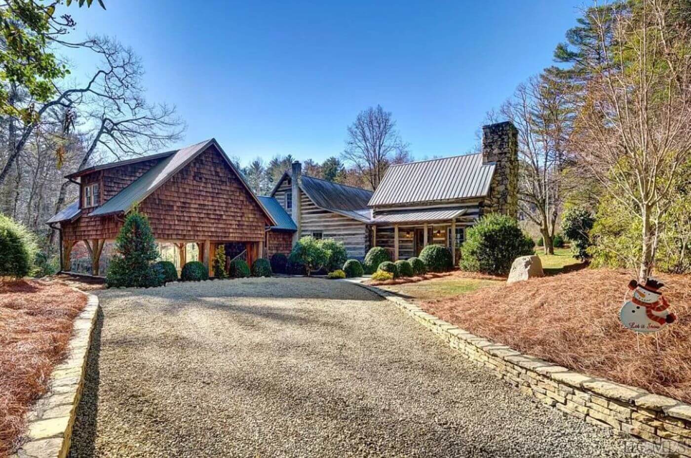 A large cabin in North Carolina with a paved road and old style cabin wood and mortor