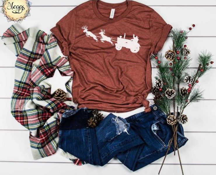 Tshirt with an image on it of a tractor pulled by flyign reindeer