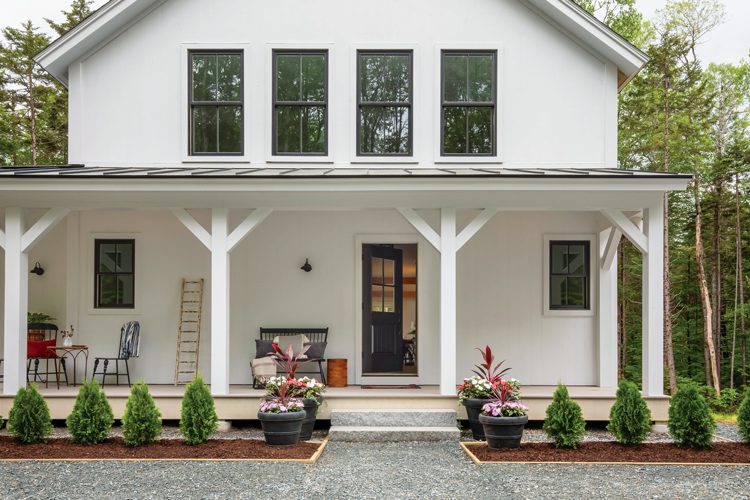 The exterior of the Project House is white with a large farmhouse porch