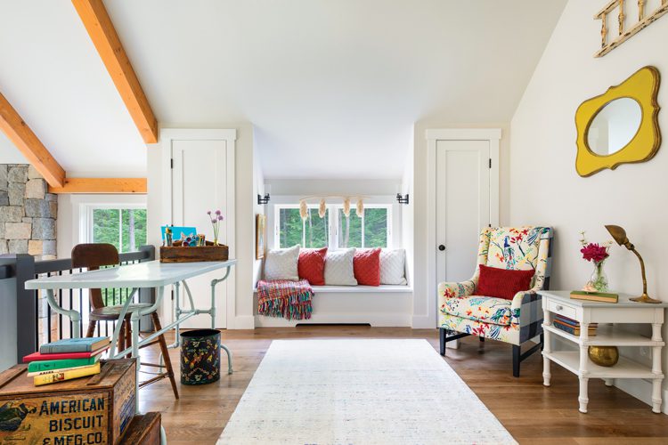 The loft of the Project House has a wood floor and many unique pieces of furniture, including a vibrantly colored floral patterned chair