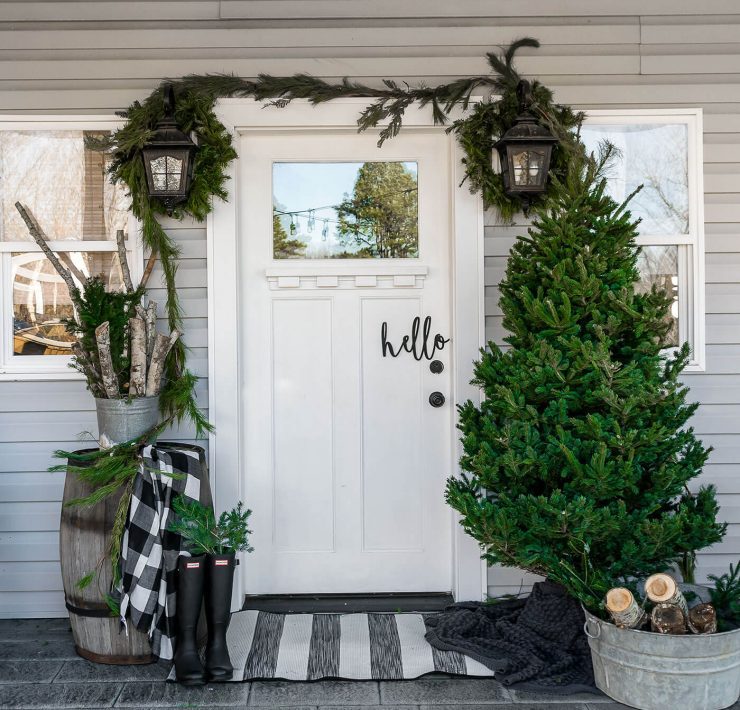 Front porch at Christmas time with tree and garlands