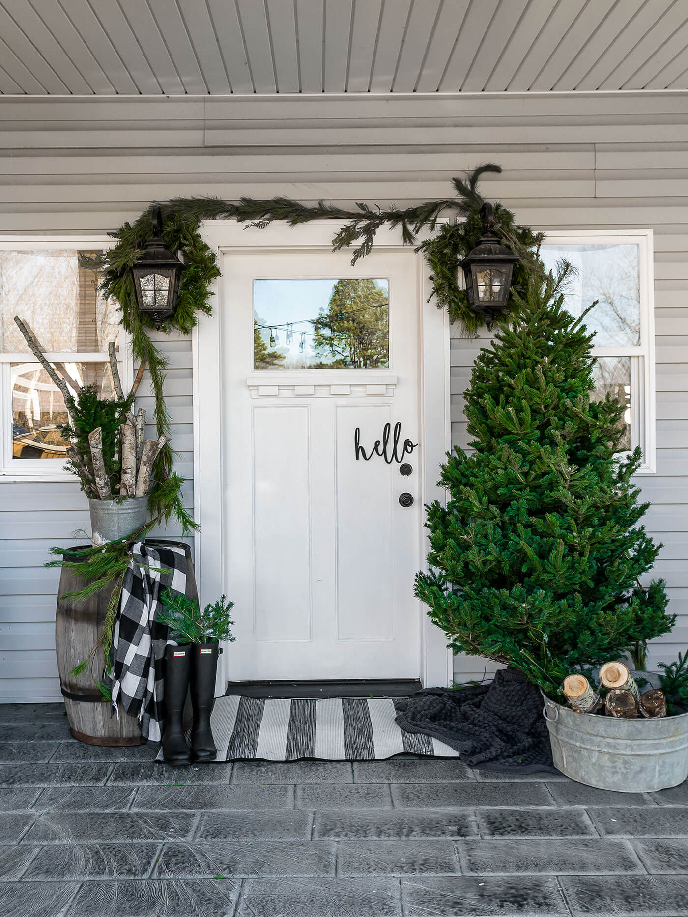 Front porch at Christmas time with tree and garlands