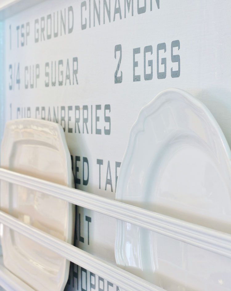 Two vintage porcelian plates on a shelf in front of the DIY recipe wall