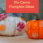 Two no carve pumpkins decorated with floral patterns in orange, white and pink