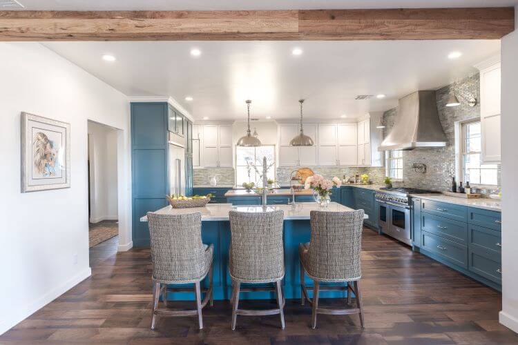 Peacock blue kitchen cabinets are paired with white upper cabinets and beautiful white walls