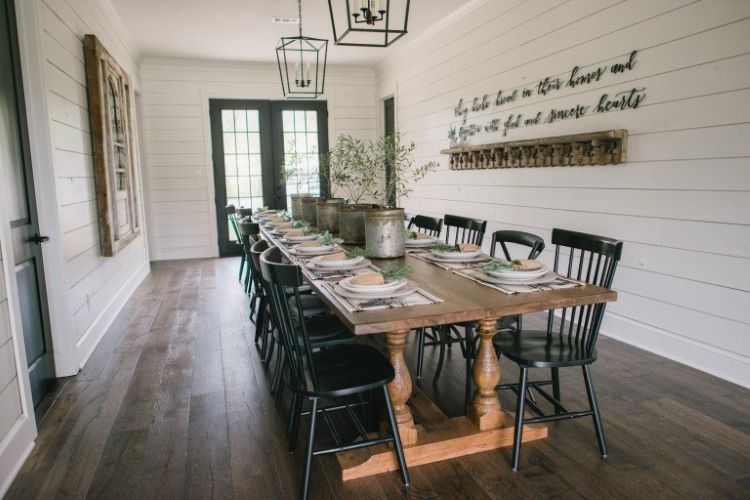 A 17 foot wood table in the dining room covered in white shiplap