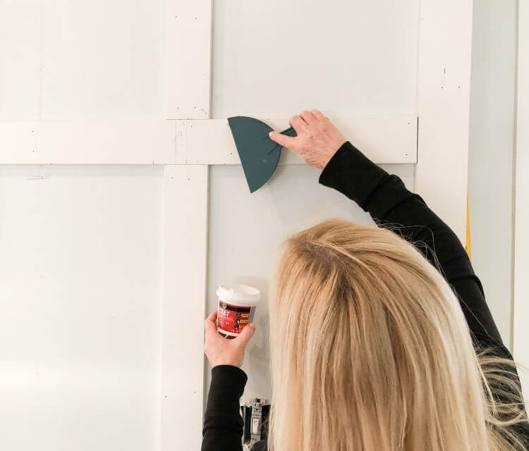 A woman covers the holes before the painting of the wall can begin