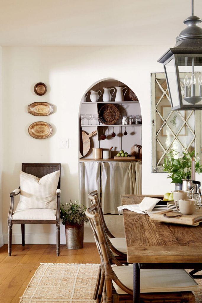 Dining room with archway, rustic table and lantern pendant light