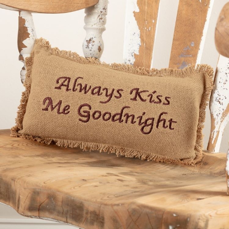 A burlap pillow with the words, "Always Kiss Me Goodnight."