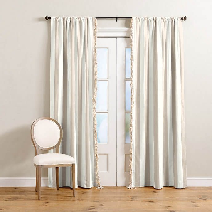 Fringed striped curtains against a white background